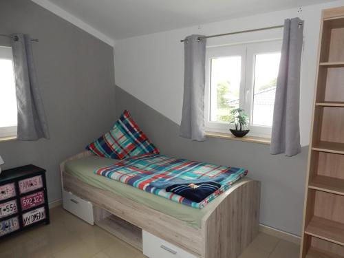een futonbed in een kamer met 2 ramen bij Apartment Haus 25 in Velten