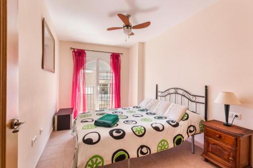 sypialnia z łóżkiem i wentylatorem sufitowym w obiekcie Vacaciones Sol y Playa w mieście Puerto de Mazarrón