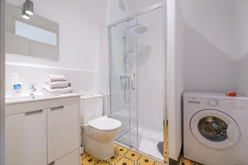 a bathroom with a shower and a washing machine at Rosario 2 in Vinarós