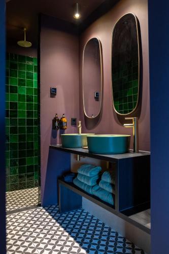 a bathroom with two sinks and two mirrors at Boutique Hotel de Bungelaer in Beers