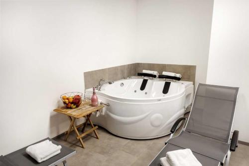 baño con bañera blanca y silla en Chic Apartments with Finnish Sauna and Jacuzzi en Kranjska Gora