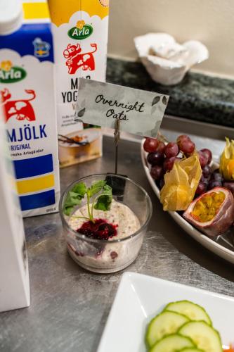 a table with a bowl of food and a plate of fruit at Park Hotel Linköping Fawlty Towers in Linköping