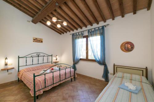 1 dormitorio con 2 camas y ventana en Il Pino - appartamento Ciliegio, en Cecina