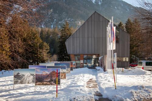 a building in the snow with signs in front of it at Chic Apartments with Finnish Sauna and Jacuzzi in Kranjska Gora