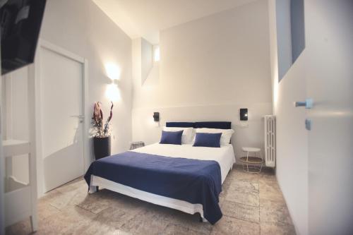 una camera da letto con un grande letto con lenzuola e cuscini blu di Terrazzini Cibele ad Andria