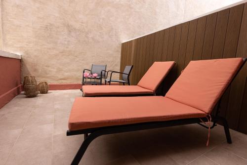 two orange chairs sitting in a waiting room at Hôtel & Espace Bien-être La Maison du Lierre in Biarritz
