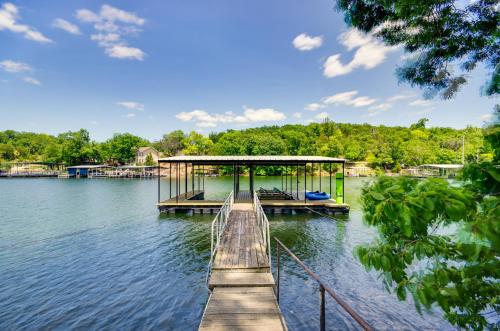 a dock on a lake with a building on it at Dock and Boat Slip Lakefront Osage Beach Home! in Osage Beach