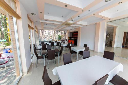 a dining room with a white table and chairs at Intea Hotel in Golem