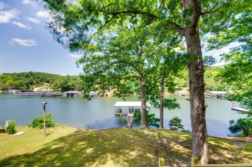 a boat dock on a lake with trees at Dock and Boat Slip Lakefront Osage Beach Home! in Osage Beach