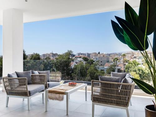 a living room with a table and chairs and a balcony at Sanders Park Central Residences in Limassol
