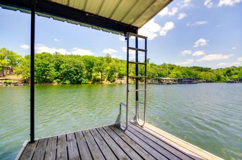 a dock with a ladder on the side of a lake at Dock and Boat Slip Lakefront Osage Beach Home! in Osage Beach