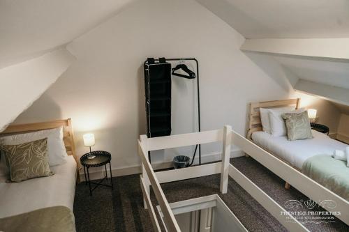 um quarto no sótão com 2 camas e uma escada em Fell Croft by Prestige Properties SA em Dalton in Furness