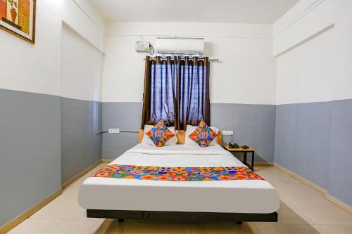 ナーシクにあるFabHotel Bhakti Sankulのベッドルーム1室(大型ベッド1台付)