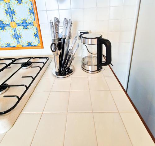 a kitchen counter with a coffee pot and utensils at Varigotti Tropical Garden - full floor apartment in Varigotti