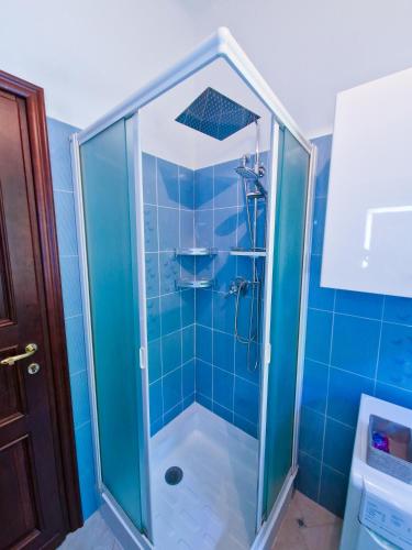 a bathroom with a shower with blue tiles at Varigotti Tropical Garden - full floor apartment in Varigotti