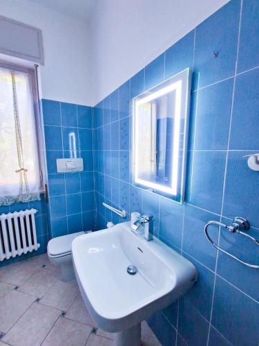 a blue tiled bathroom with a sink and a toilet at Varigotti Tropical Garden - full floor apartment in Varigotti