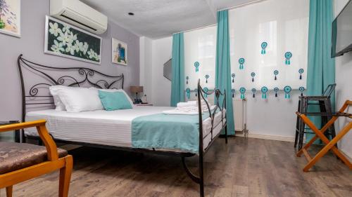 a bedroom with a bed and a chair and a window at Bertiz Mignon in Bozcaada