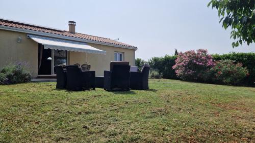 une cour avec des chaises en face d'une maison dans l'établissement Chambre d'hôte Lempautoise à côté domaine d'en flore et château de la Rode, à Lempaut