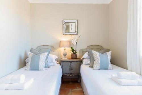 two beds in a room with white and blue pillows at Pretty Historical Village House in Grimaud