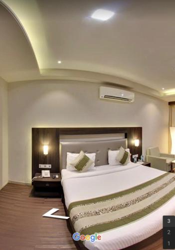 sypialnia z dużym białym łóżkiem w pokoju w obiekcie Hotel Signature w mieście Ichalkaranji