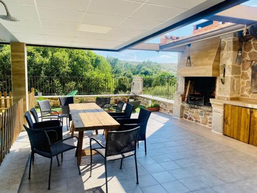 a patio with a table and chairs and a fireplace at Raices in Robledondo