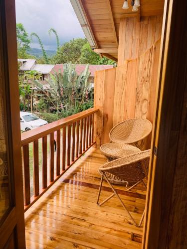 a wooden balcony with a chair on a wooden floor at La Casa de Cecilia Mindo in Mindo