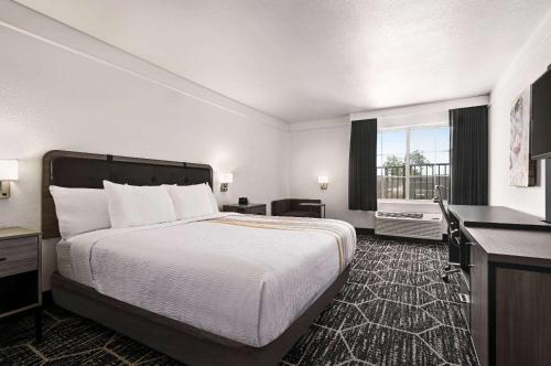 a hotel room with a bed and a window at La Quinta by Wyndham Hesperia Victorville in Hesperia