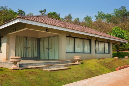 a small house with a porch in front of it at Urmilaa Green County Resort 35 KM From Kolhapur in Kolhapur