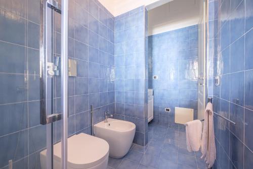 Villa Chiara في ليباري: حمام من البلاط الأزرق مع مرحاض ومغسلة