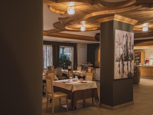 uma sala de jantar com mesa e cadeiras em Hotel Crozzon em Madonna di Campiglio