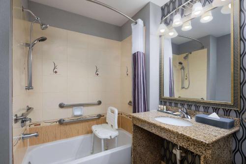 a bathroom with a tub and a sink and a mirror at La Quinta by Wyndham Savannah Airport - Pooler in Savannah
