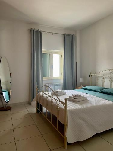 una camera da letto con un letto con tende blu e uno specchio di Villa Claudia - appartamento A a Corazzello