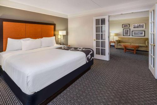 a hotel room with a large bed and a living room at La Quinta by Wyndham Pueblo in Pueblo