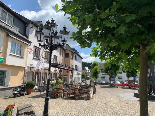 a street with a lamp post and tables and chairs at Ritterstube - Eifelstuben mit Charme, Nähe See und Burg, außergewöhnlich, Vulkaneifel in Ulmen