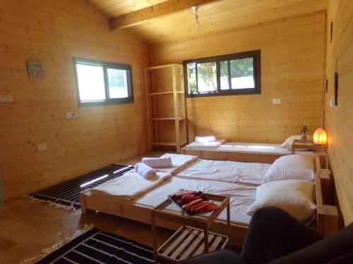a room with a large bed in a wooden cabin at תפארת עזך in Kefar H̱ananya