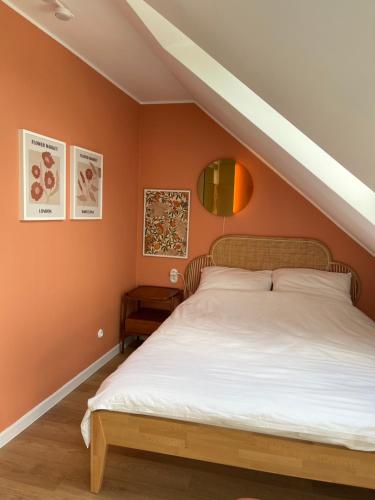 a bedroom with orange walls and a large bed at Slow Home in Dziemiany