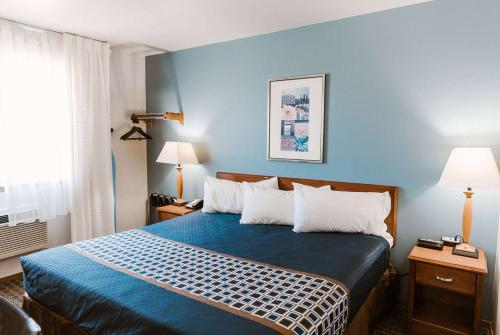 a hotel room with a bed with blue walls at Travelodge by Wyndham Worland in Worland