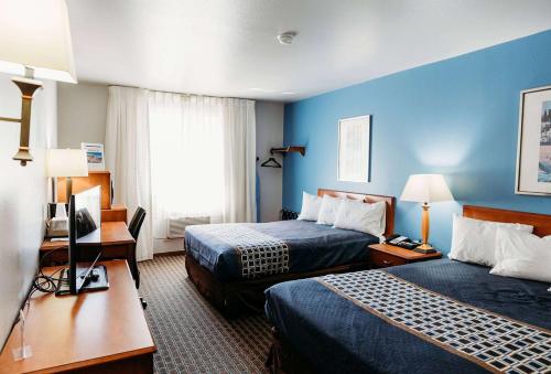 Habitación de hotel con 2 camas y escritorio en Travelodge by Wyndham Worland en Worland