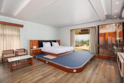 a bedroom with a large bed and a large window at Urmilaa Green County Resort 35 KM From Kolhapur in Kolhapur