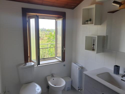 La salle de bains est pourvue de toilettes, d'un lavabo et d'une fenêtre. dans l'établissement ETNA VIEW, à Valverde