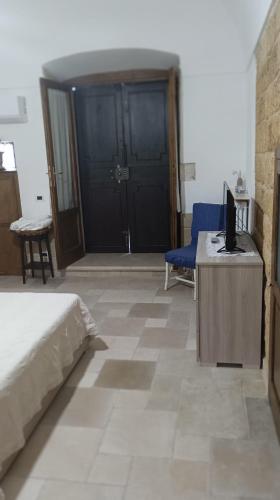 a bedroom with a bed and a desk with a television at dimora arcobaleno in Gioia del Colle