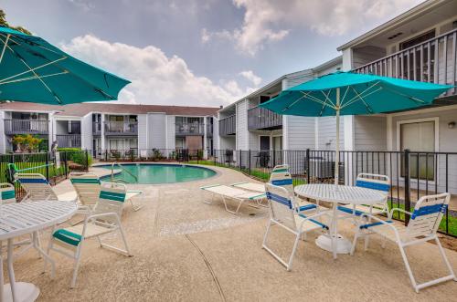 a patio with tables and chairs and a pool at Montgomery Vacation Rental with Pool Access! in Montgomery