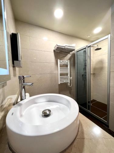 a bathroom with a white sink and a shower at Oasis Chakvi apartment 1406 in Chakvi