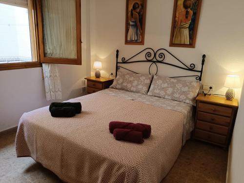 ein Schlafzimmer mit einem Bett mit zwei Handtüchern darauf in der Unterkunft El Roalico in Los Alcázares