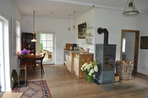 a kitchen and living room with a stove in it at Zauberhaftes englisches Cottage am Gutshaus in Groß Schoritz