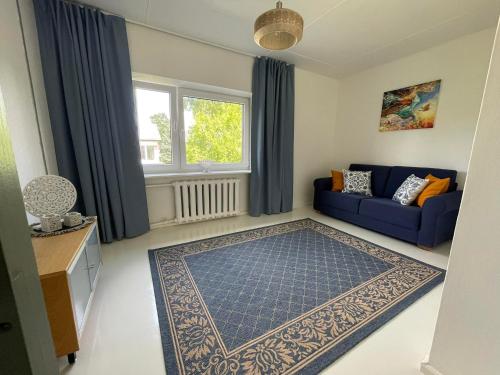 a living room with a blue couch and a window at Merelähedane peremaja Pärnus in Pärnu