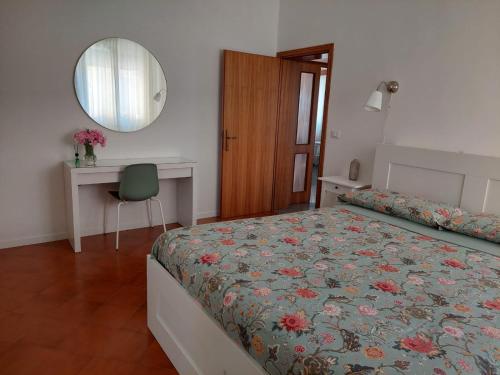 1 dormitorio con cama, escritorio y espejo en Casetta Mia - Holiday Family House, en Santarcangelo di Romagna