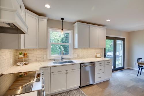 a kitchen with white cabinets and a sink at Modern Rapid City Vacation Rental with Deck in Rapid City