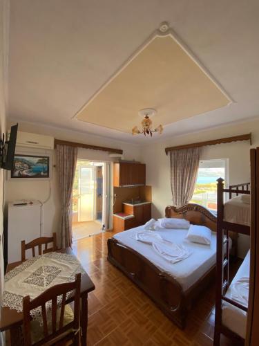 1 dormitorio con 1 cama, mesa y sillas en Villa Tani Ksamil, en Ksamil