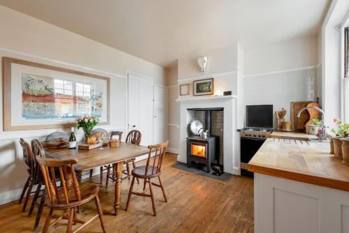 a kitchen and dining room with a table and chairs at Cliff-top Coastguard's Cottage, an Off-Grid Escape in Weybourne